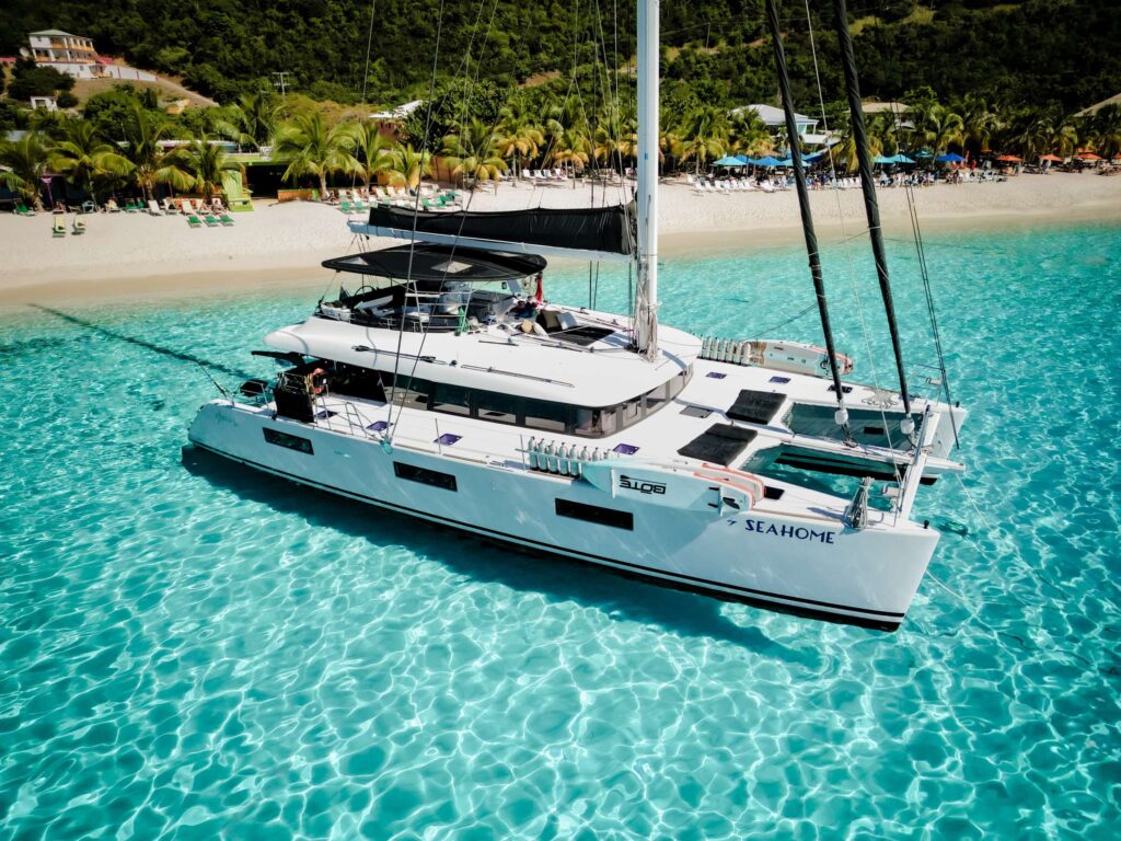 Seahome I, a popular Lagoon 620 that sleeps 10 adults at anchor in famous White Bay, BVI. Available for all inclusive crewed yacht charter by Wlms Yacht Charters